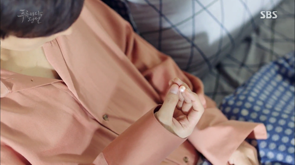 Joon Jae holding Sim Cheong's pink pearl of happiness